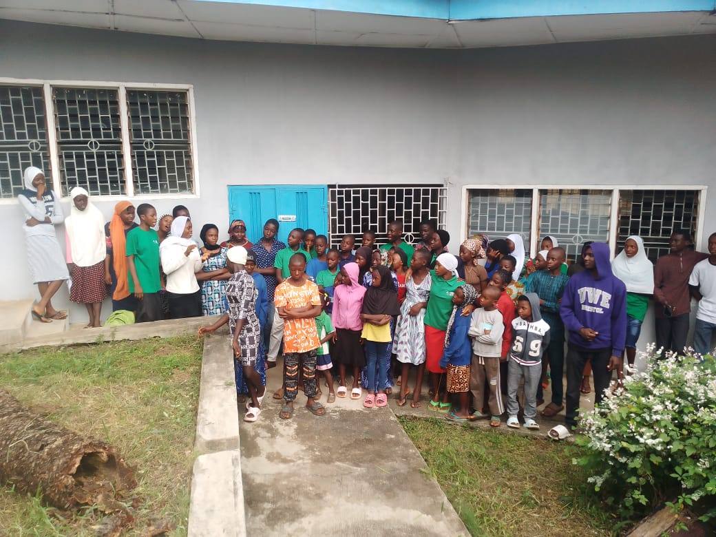 A group of children and young people gathered outside a building in Kwara State.